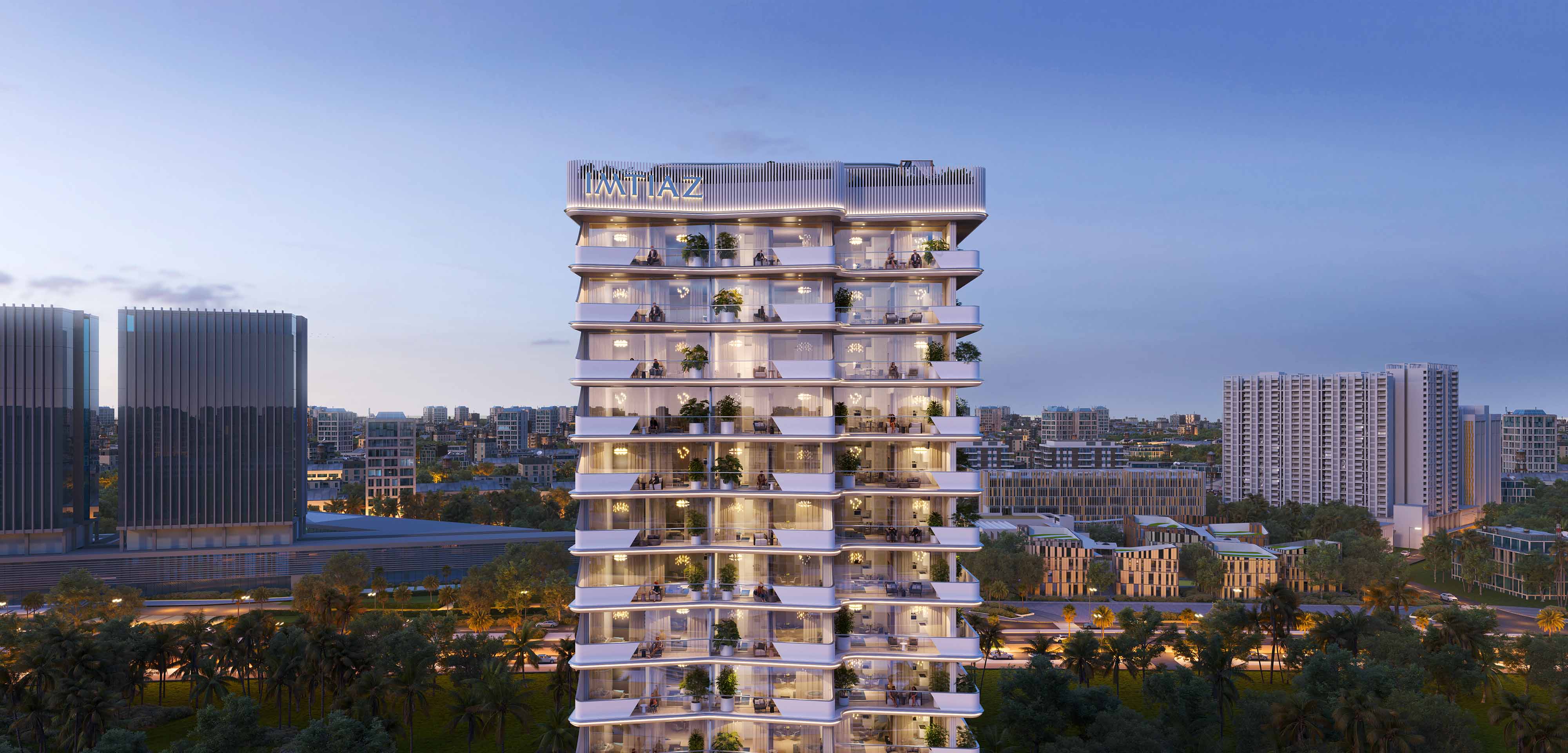 Cove Edition I By Imtiaz 1 A modern, illuminated residential tower with balconies, surrounded by urban buildings and greenery at dusk.